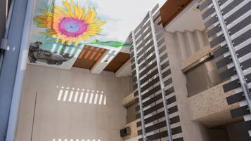 Un interior moderno con un mural de sol, una escalera y vistas al exterior.