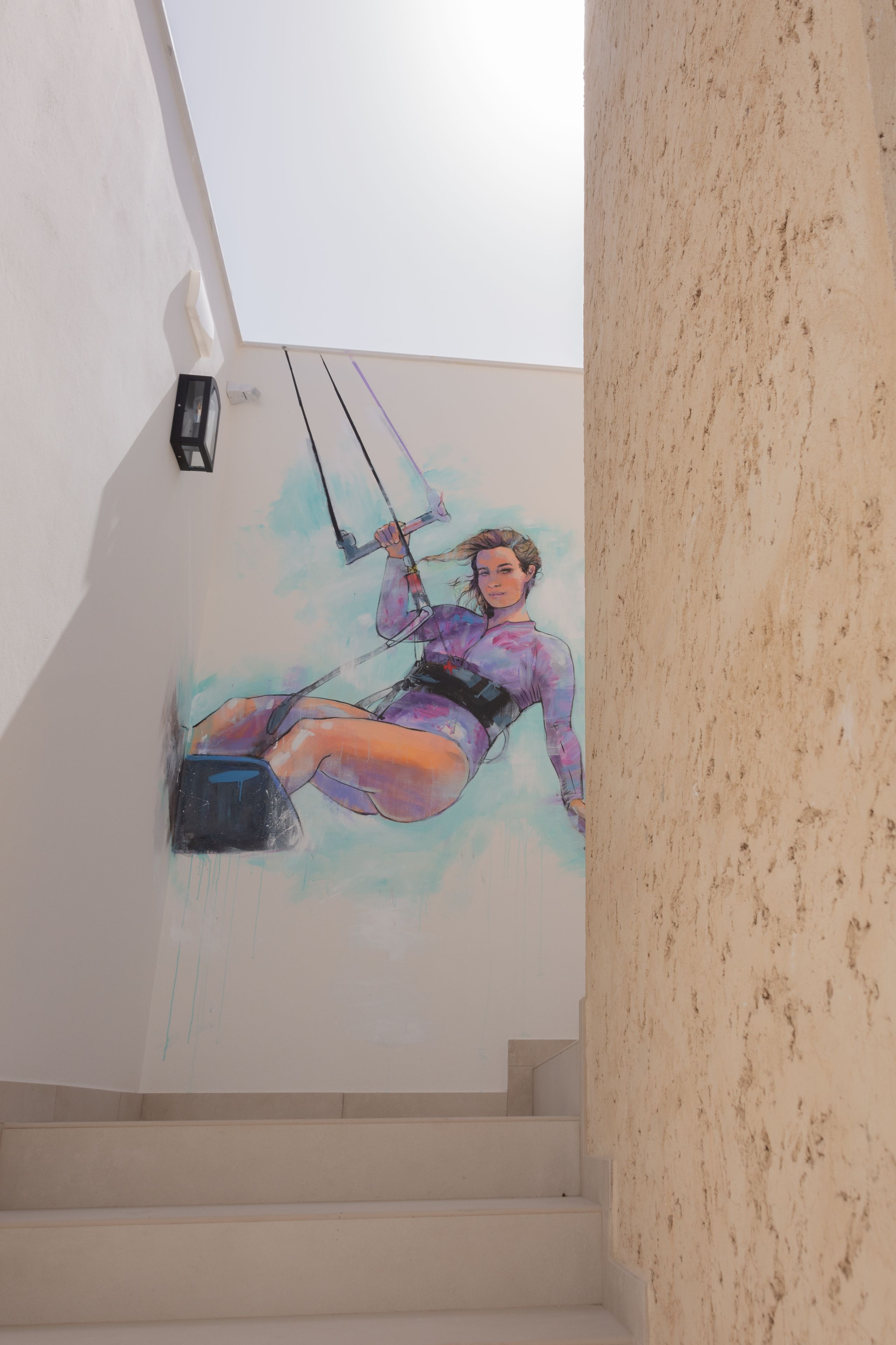 A mural of a person in a purple outfit on a staircase wall.