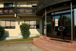 A modern building with a curved entrance, a balcony, and a sign indicating a restaurant. - Tennis- und Freizeitzentrum Neudörfl (Neudoerfl)