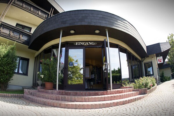 A building with a curved entrance, a sign reading "EINGANG," and steps leading up to the door. - Tennis- und Freizeitzentrum Neudörfl (Neudoerfl)