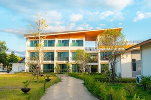 Un hôtel moderne à plusieurs étages, doté d’une cour intérieure, de grandes fenêtres et d’une galerie couverte.