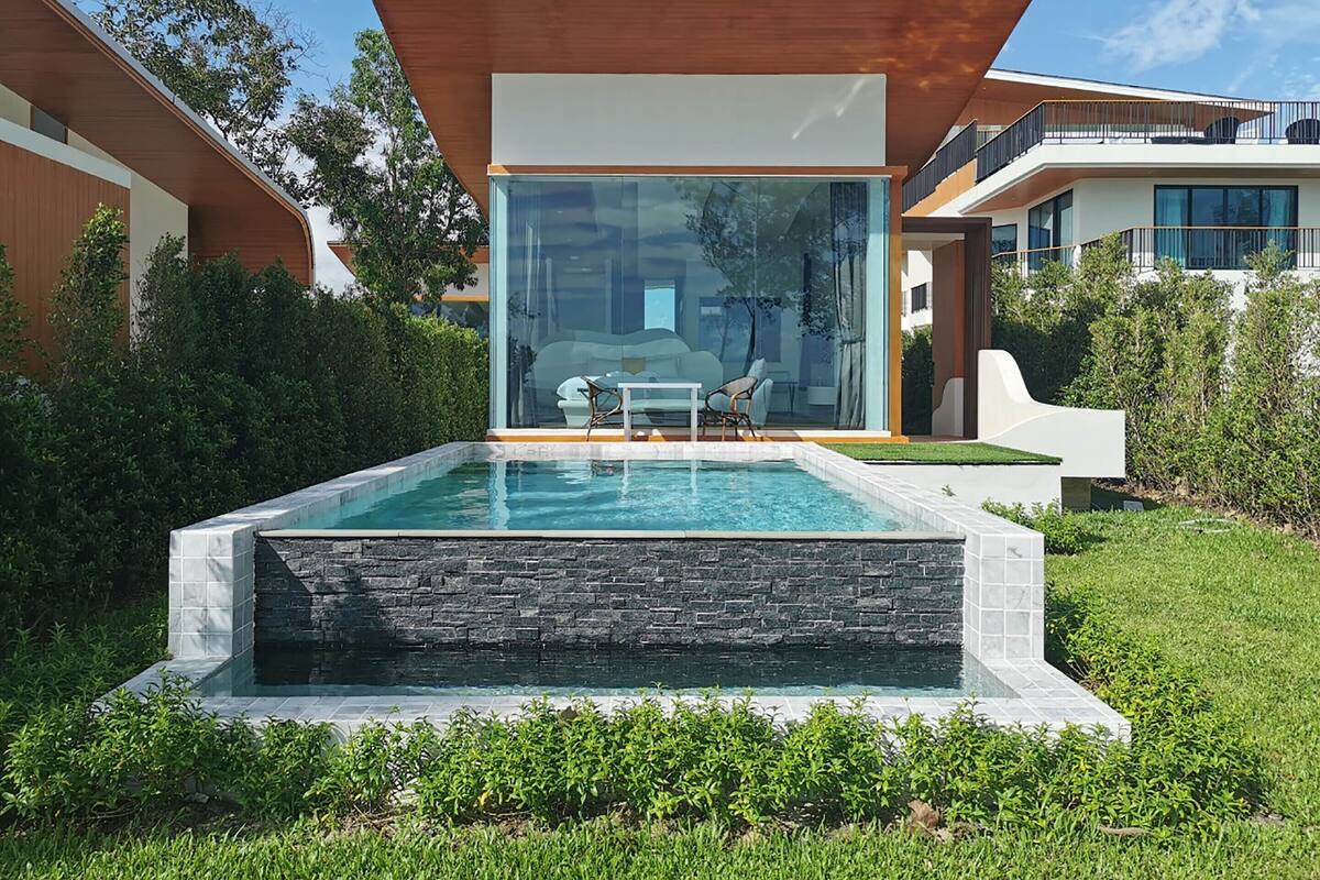 Une maison moderne dotée d’un patio entièrement vitré et d’une piscine.
