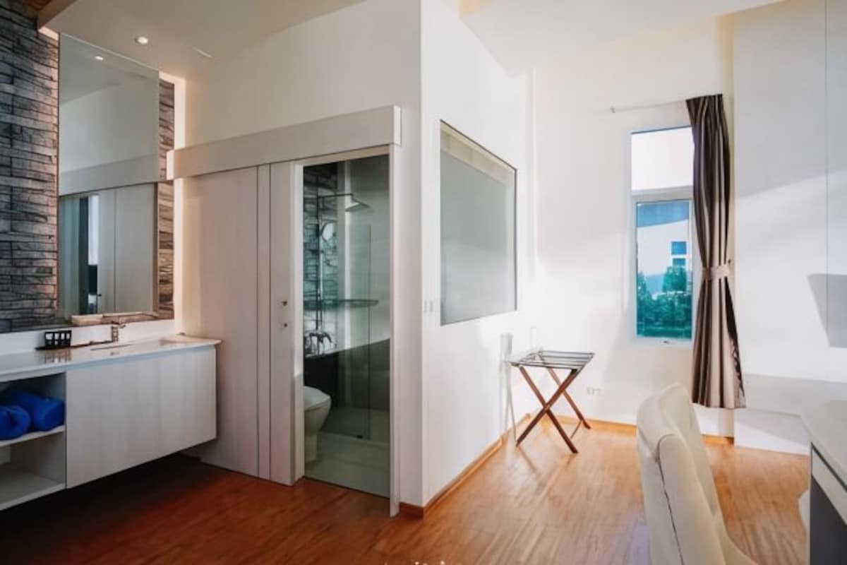 Une salle de bain moderne avec une douche, un miroir et une porte en verre donnant sur un dressing.