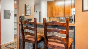 A kitchen with wooden cabinets, a marble countertop, and a built-in oven. - Cozy Mammoth Studio – Fireplace, Pets Welcome (Mammoth Lakes)