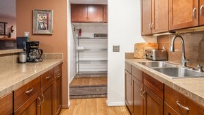 A kitchen with wooden cabinets, a stainless steel sink, and a toaster. - Cozy Mammoth Studio – Fireplace, Pets Welcome (Mammoth Lakes)