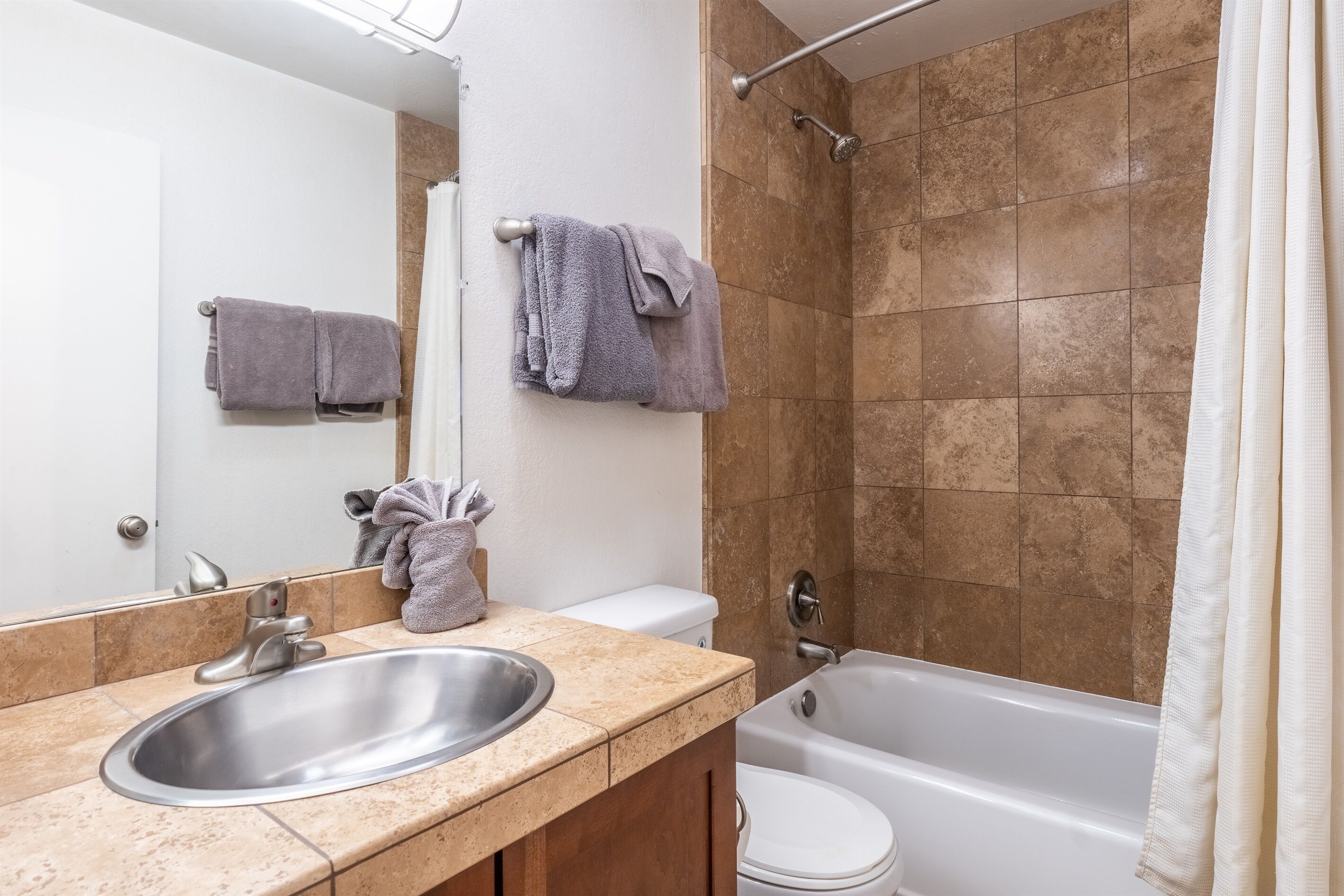 A bathroom with a sink, toilet, and bathtub.