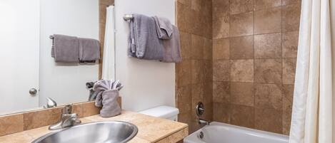A bathroom with a sink, toilet, and bathtub.