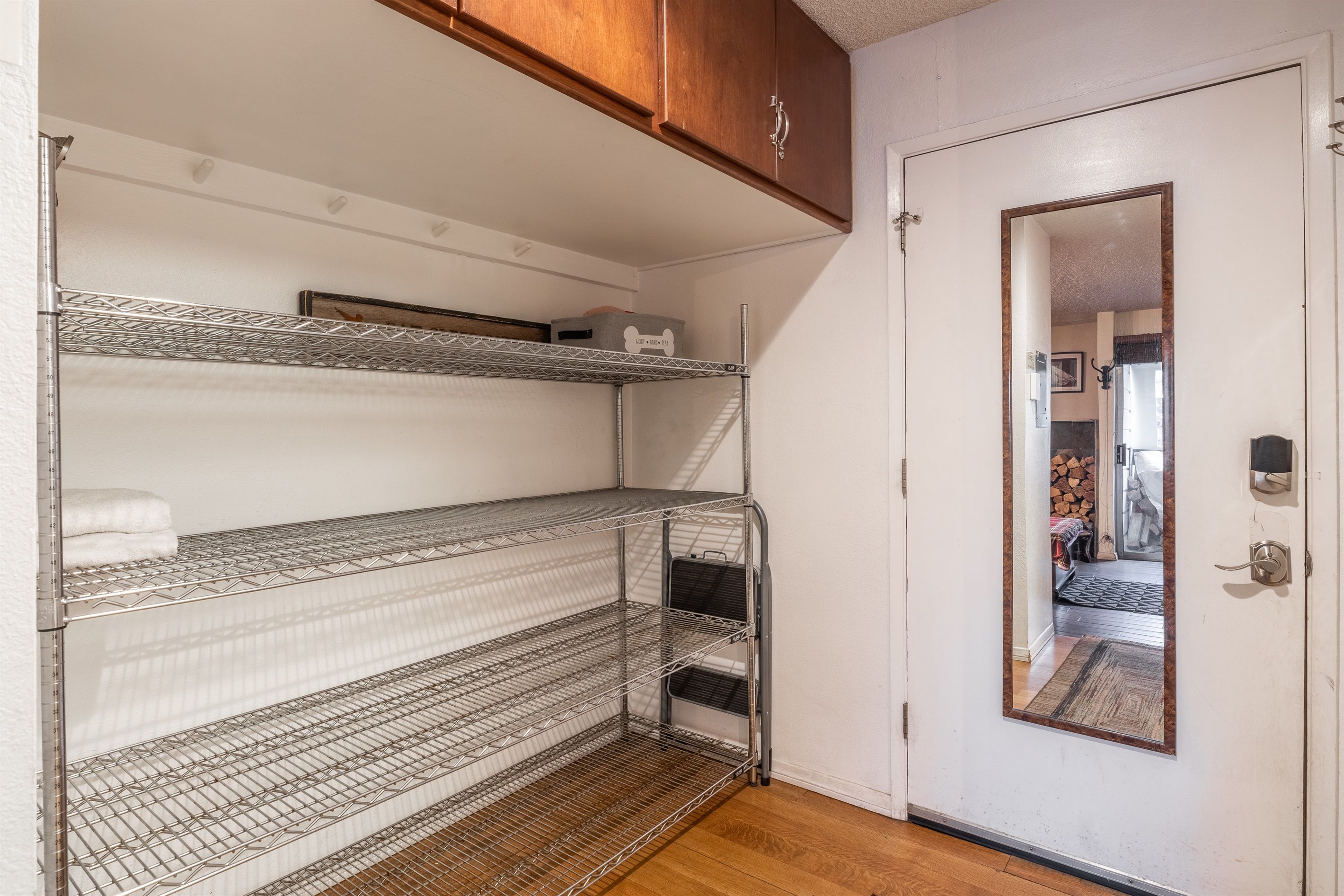Ein Zimmer mit einem Etagenbett, einer Tür mit Spiegel und einem Holzschrank.