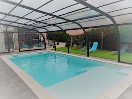 Una piscina techada, sillones reclinables de piscina