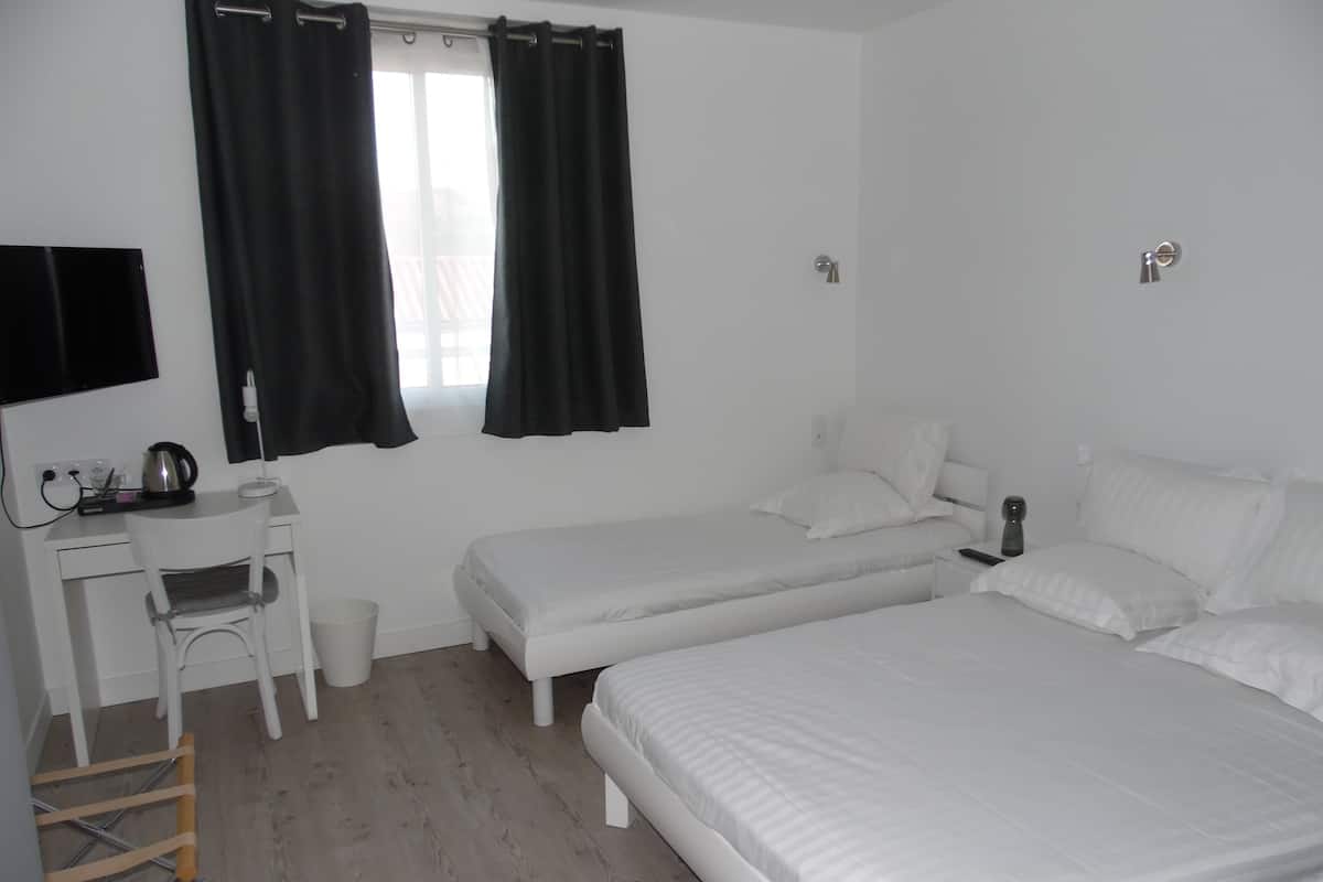 A room with two beds, a desk, and a chair.