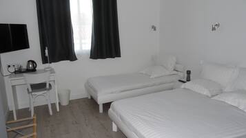 A room with two beds, a desk, and a chair.