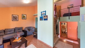 Ein Wohnzimmer mit einer Couch, einem Couchtisch und Kunstwerken an den Wänden.