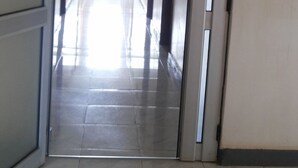 Un pasillo con piso de baldosas que conduce a una habitación luminosa.