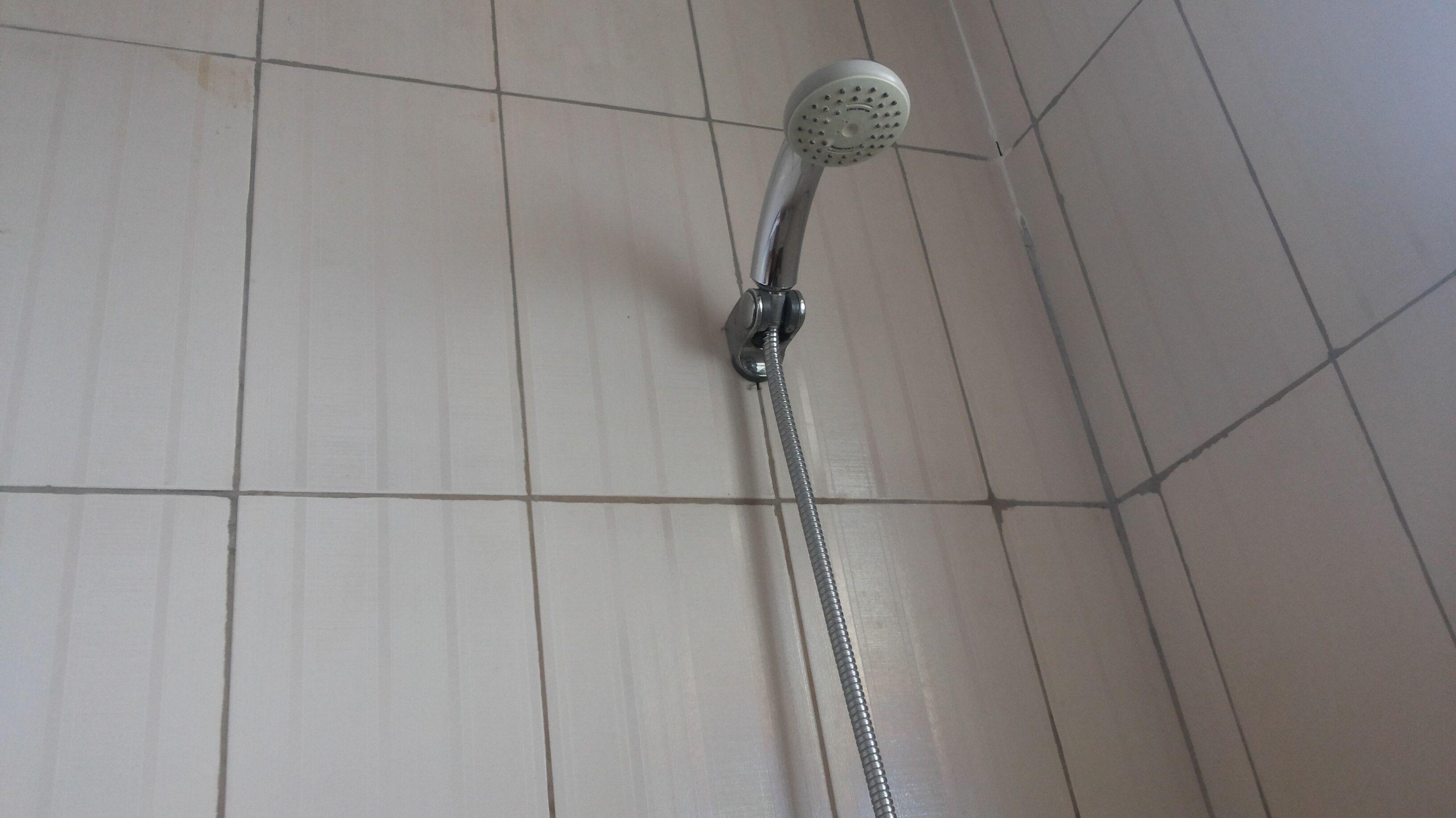 Una ducha con cabezal de ducha de mano y manguera flexible.