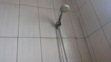 Una ducha con cabezal de ducha de mano y manguera flexible.