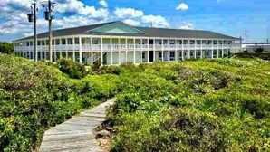 A large, single-story building with a green roof and multiple windows. - 50 Steps to Private Beach•Oceanside Community•1st Floor•Pool•Kitchen•BBQ Grills (Atlantic Beach)