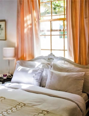 A neatly made bed with white linens and a decorative headboard. -  Old Oak Manor (Riebeek Kasteel)