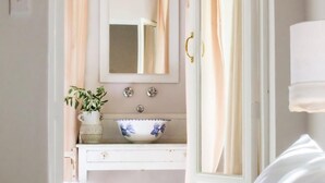 A bedroom with a bed, a bedside table, a nightstand, a dresser, a mirror, and a window with curtains. -  Old Oak Manor (Riebeek Kasteel)