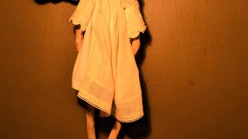 Una figura de madera con alas y vestido, colocada en una pared.