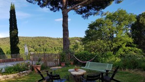 An outdoor seating area with a table, chairs, and a hammock. - Mas des Ballats (Saint-Bauzille-de-Putois)