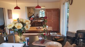 A kitchen with a sink, countertop, and a dining area with a table and chairs. - Mas des Ballats (Saint-Bauzille-de-Putois)