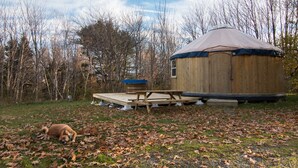 A yurt with a wooden deck and a small table.