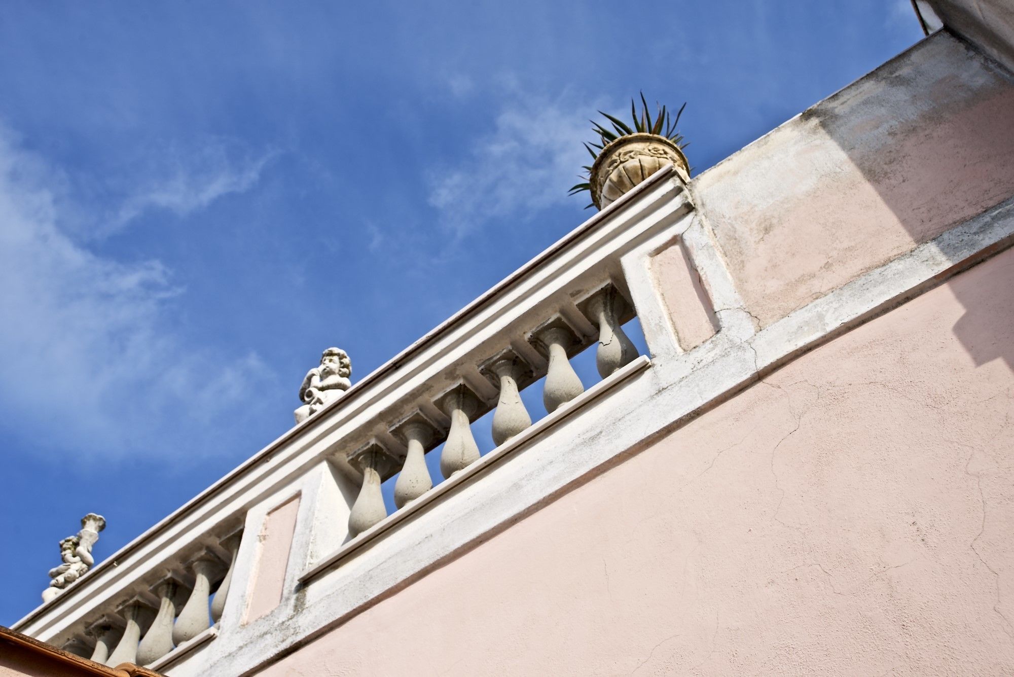 Facciata di un edificio con elementi architettonici classici, tra cui una balaustra e capitelli decorativi.