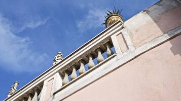 Facciata di un edificio con elementi architettonici classici, tra cui una balaustra e capitelli decorativi.