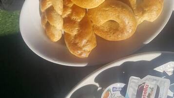 Una mesa con un plato de pasteles y un plato de fruta.