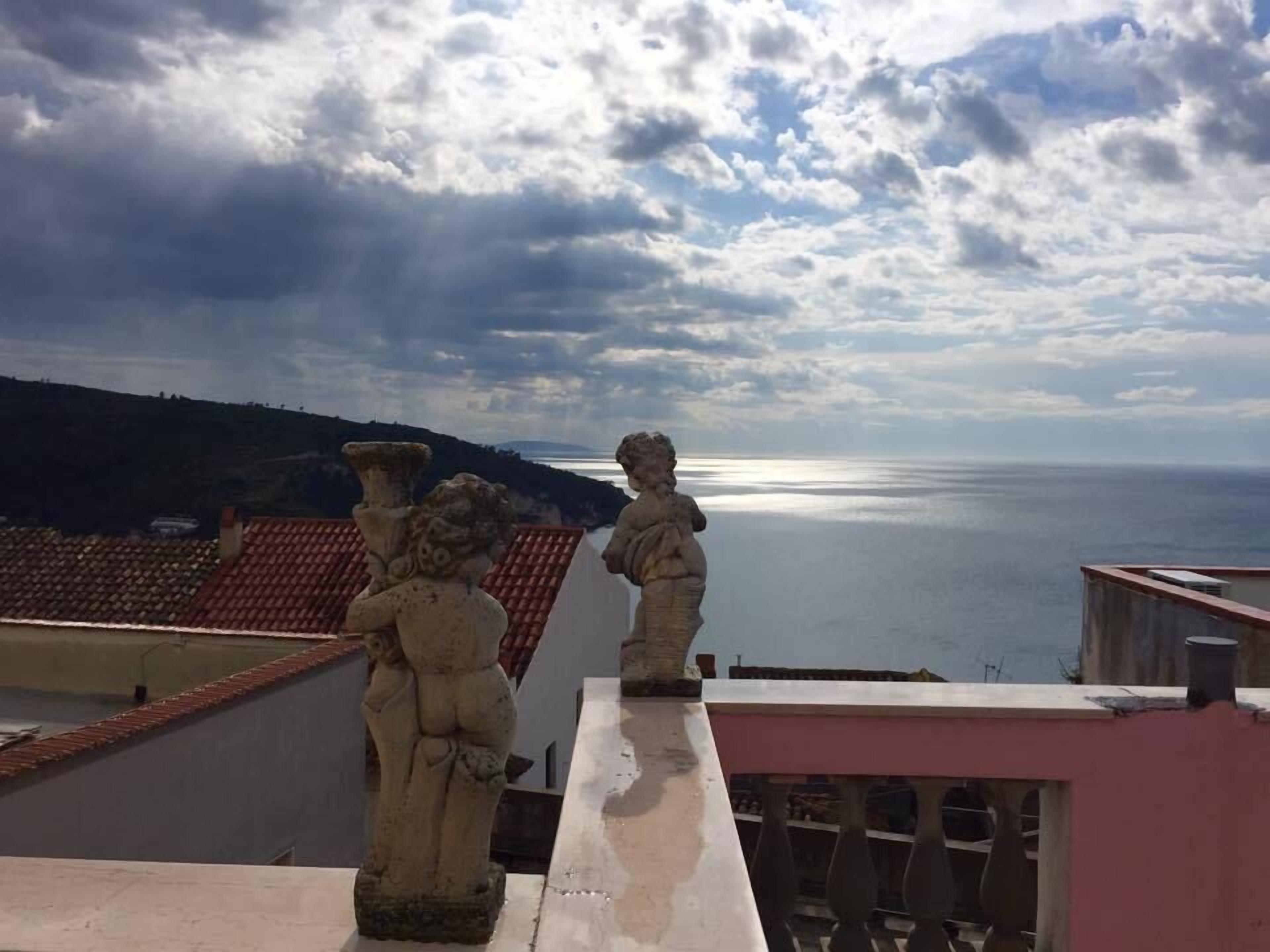 A balcony with a view of the sea and a cloudy sky.