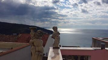 A balcony with a view of the sea and a cloudy sky.