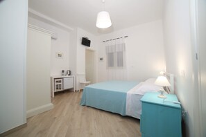 A bedroom with a bed, a nightstand, a desk, and a chair. - B&B Pippi (Morciano di Leuca)