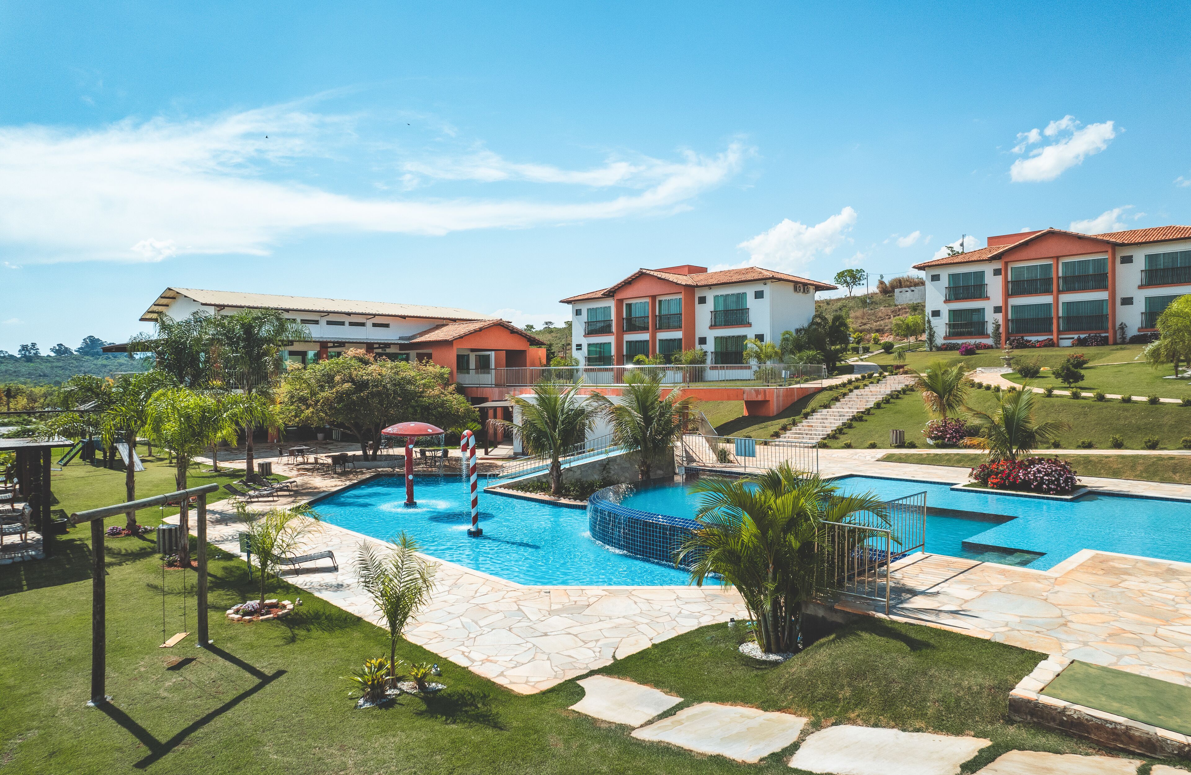 Un resort con piscina, zona de estar exterior y césped bien cuidado.