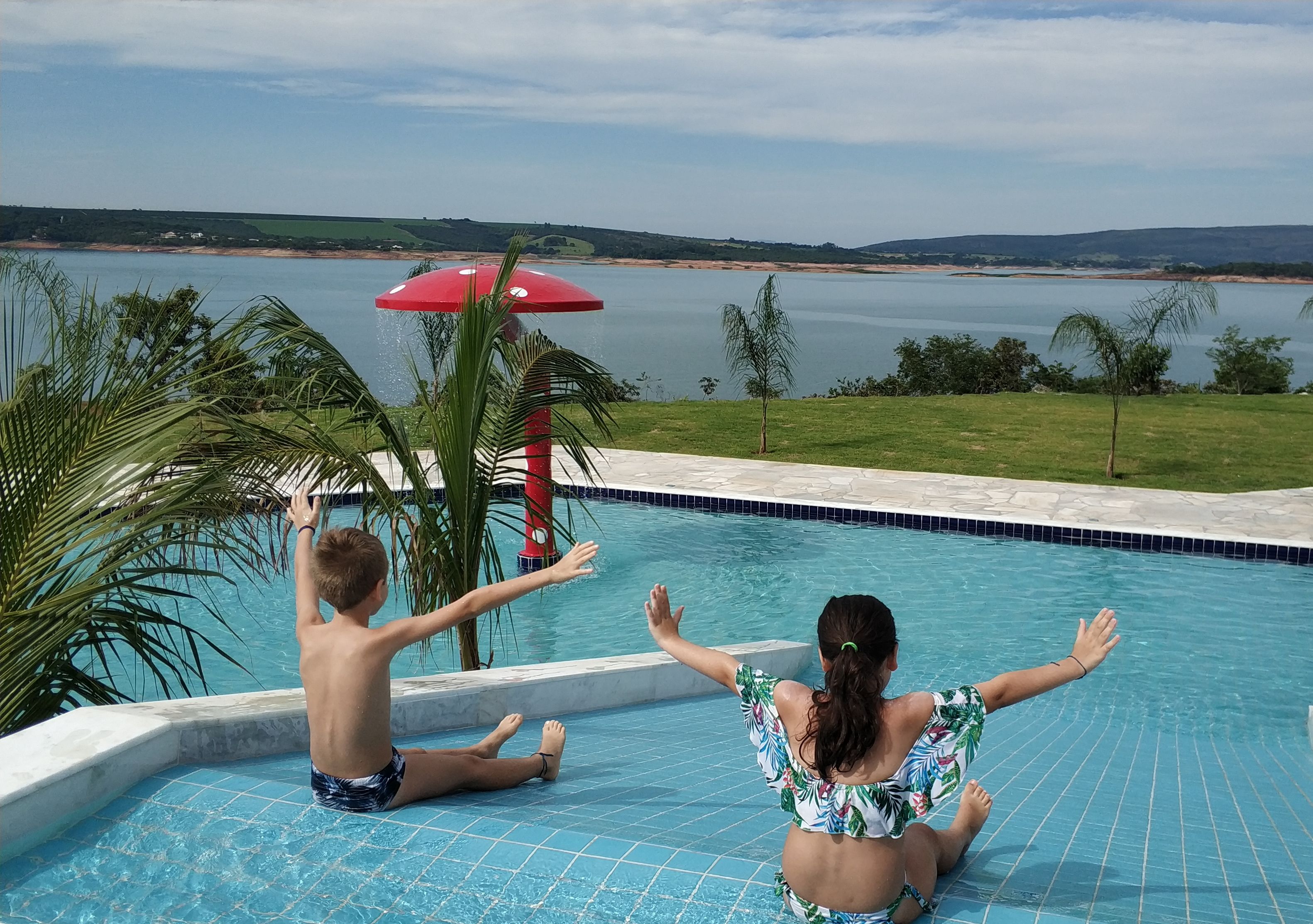 Una piscina con vistas a un lago y colinas.