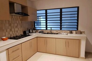 Luxe appartement | Gemeenschappelijke keuken | Een koelkast met diepvriezer, een microgolfoven, een oven, een kookplaat