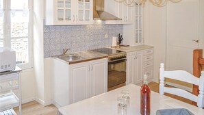 A kitchen with white cabinets, a stainless steel sink, and a wooden countertop.