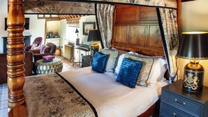 A traditional bedroom with a four-poster bed, a wooden headboard, a nightstand with a lamp, and a dresser with drawers. - The Harcourt Arms (Witney)