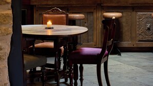 A bar area with a round table, chairs, and a candle. - The Harcourt Arms (Witney)