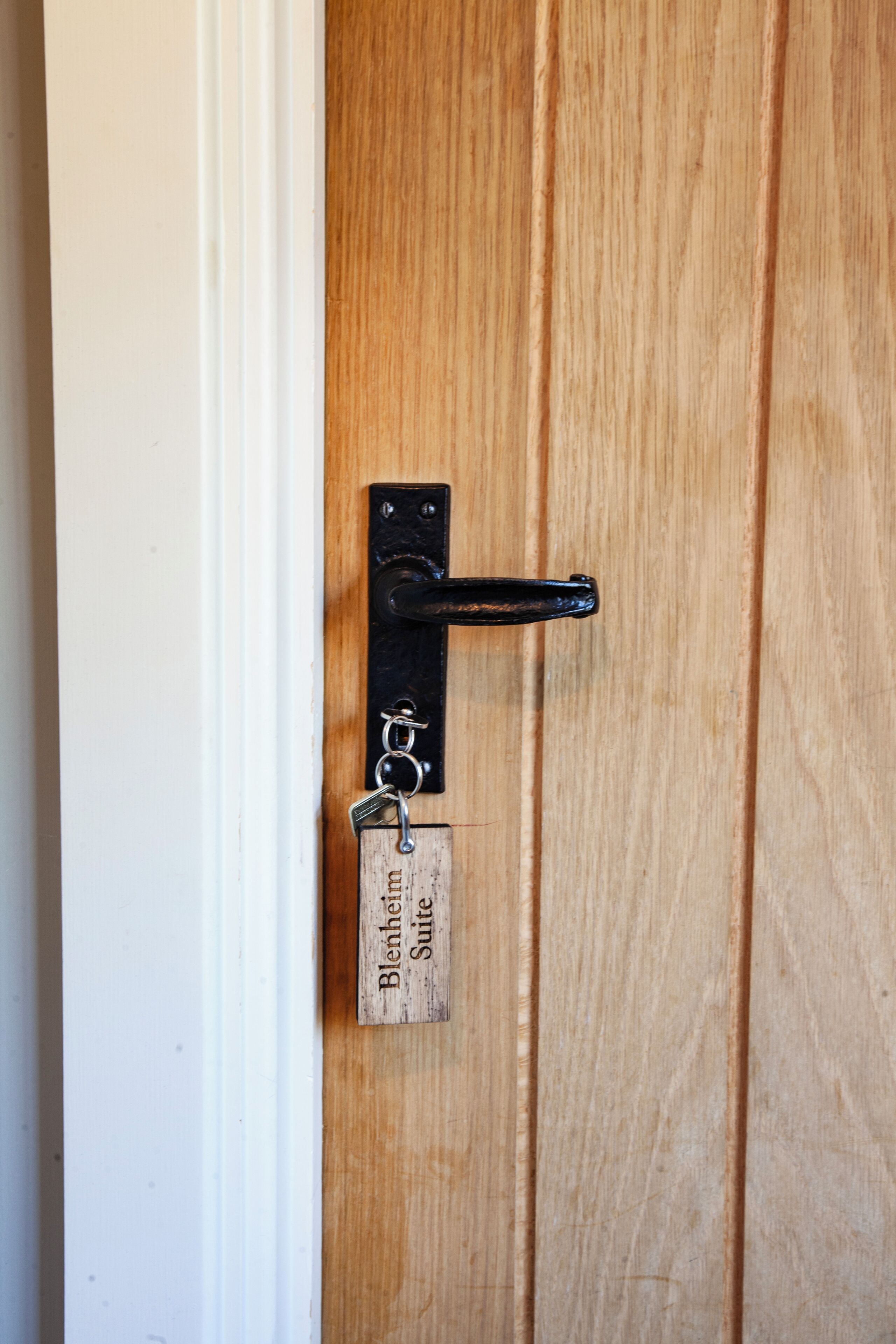 Una porta de fusta amb una manilla metàl·lica i una etiqueta amb el text 'Blankenberg Suite'.