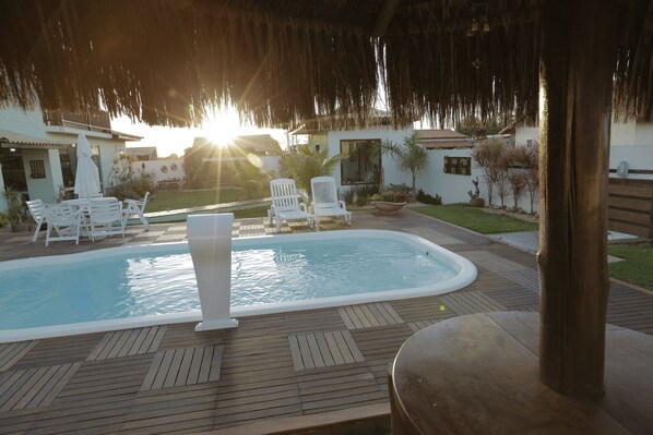 Ein Poolbereich mit Whirlpool, Liegestühlen und einer Holzterrasse.