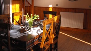 A dining area with wooden furniture, a chandelier, and a decorative wall piece. - Historic, homely village retreat with log fires, in stunning Borders. Sleeps 4/6 (Allanton)
