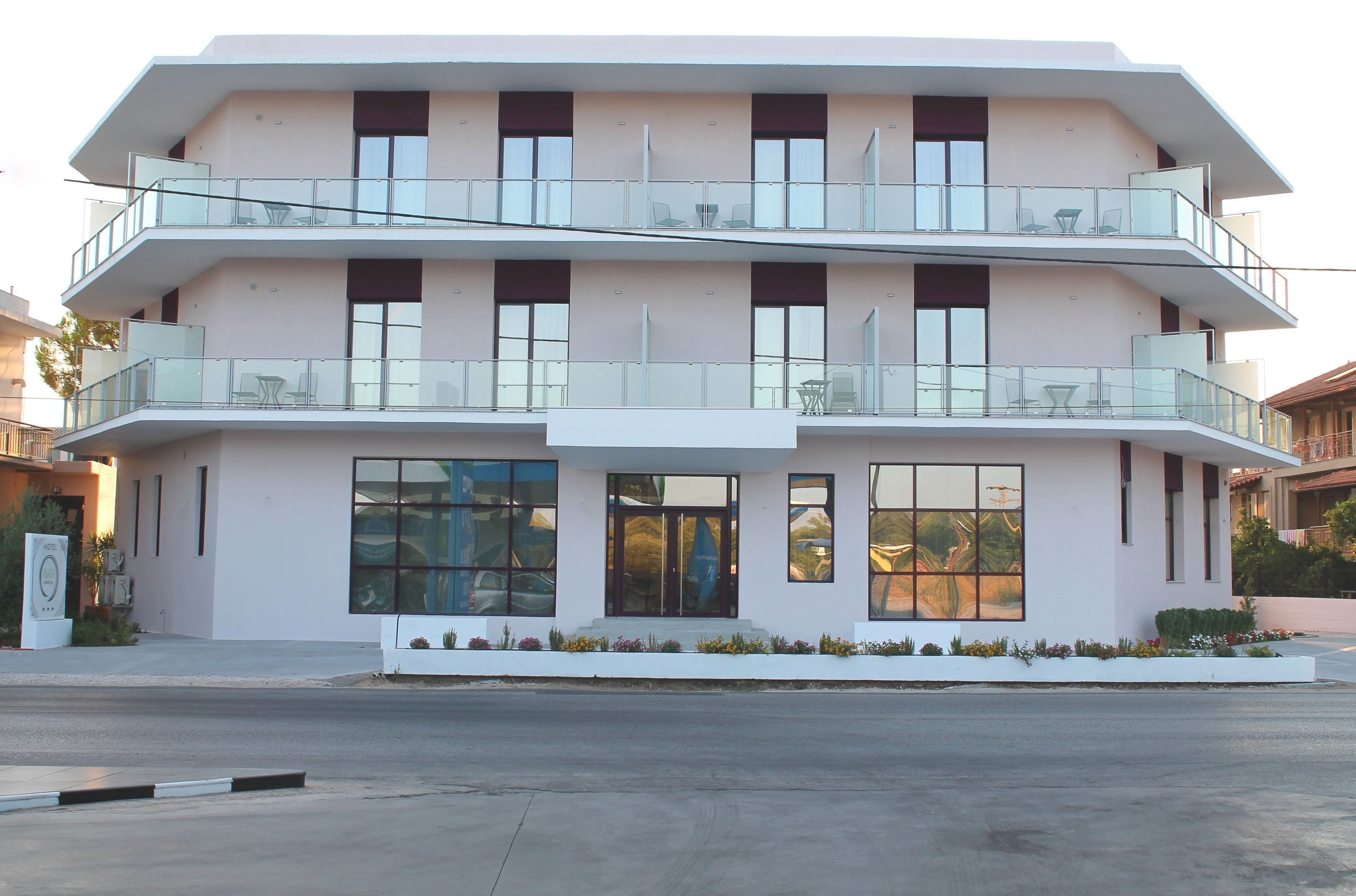 A multi-story building with balconies, large windows, and a flat roof.