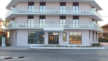Un edificio de varios pisos con balcones, ventanas amplias y techo plano.