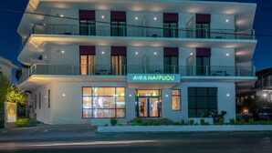 Un hotel moderno de varios pisos con balcones y ventanas amplias.