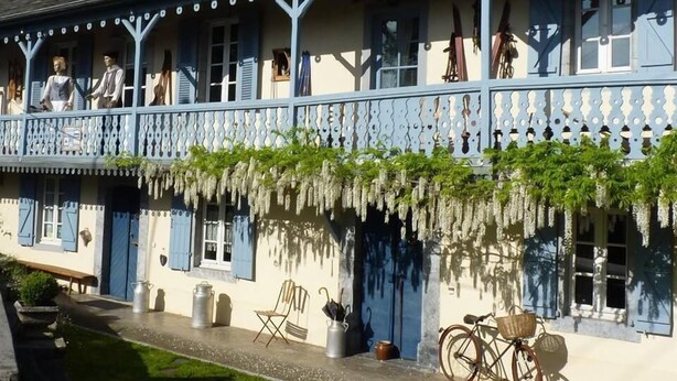 Un bâtiment traditionnel doté d’un balcon, d’un vélo et de sièges à l’extérieur.