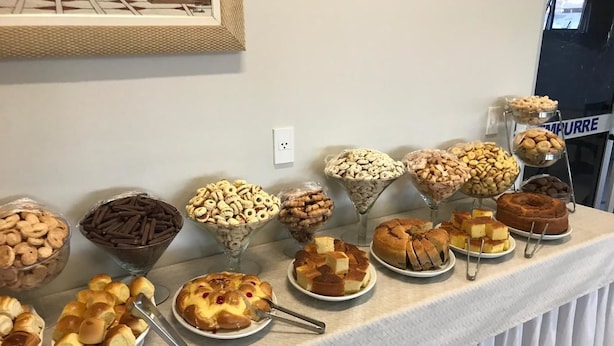 A buffet table with various baked goods and desserts. - Porto Center Hotel (Luís Eduardo Magalhães)