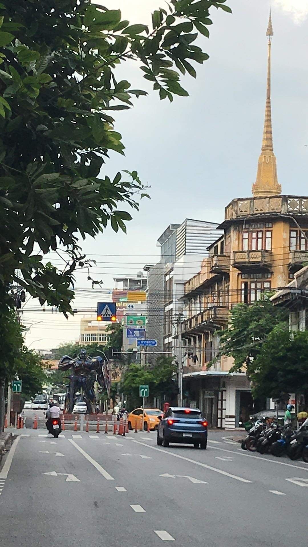 A street with buildings, a statue, and a tall tower.