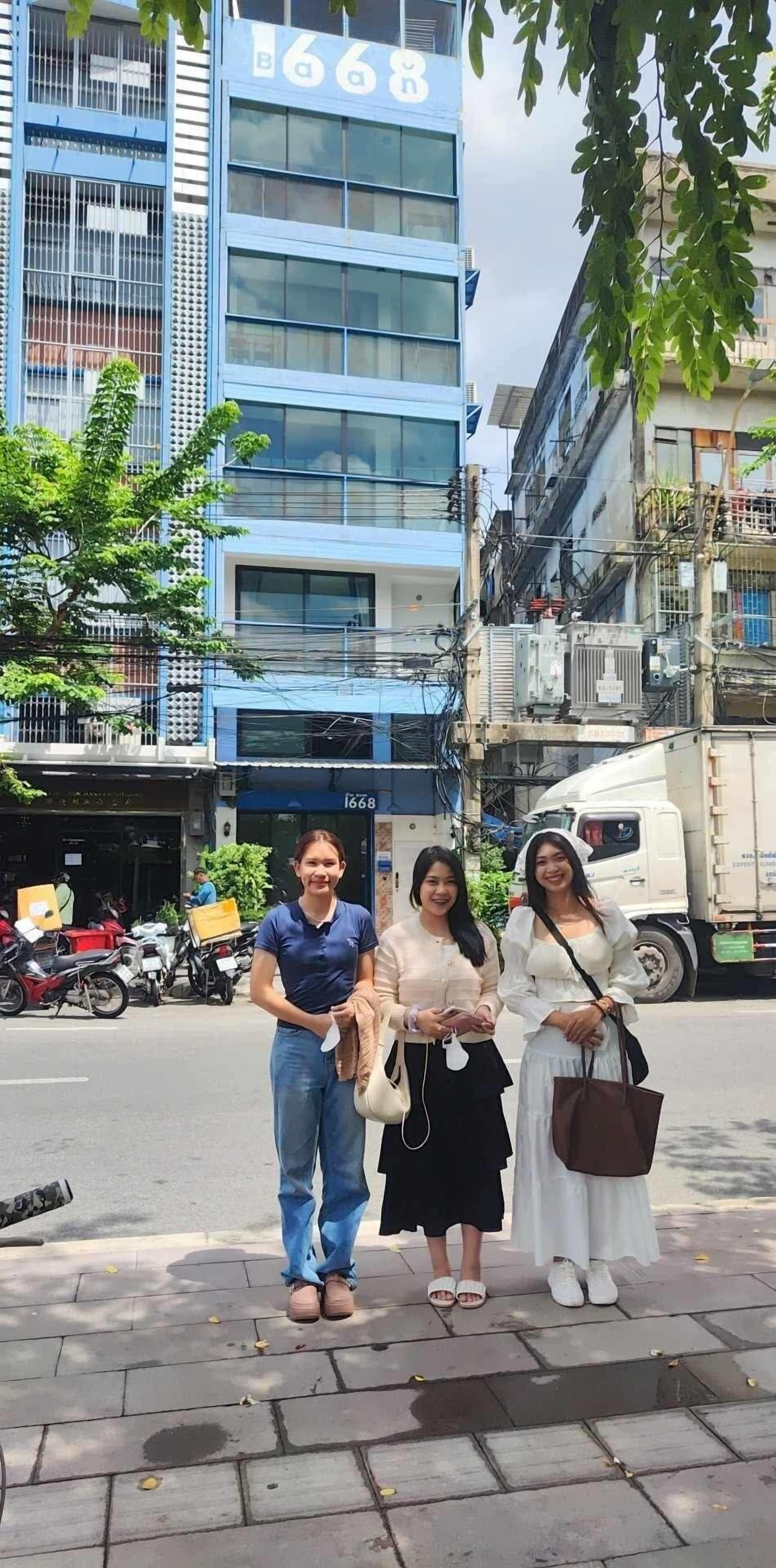 Un edificio con el número 6688 en su fachada, una calle con motocicletas estacionadas y un camión blanco al fondo.