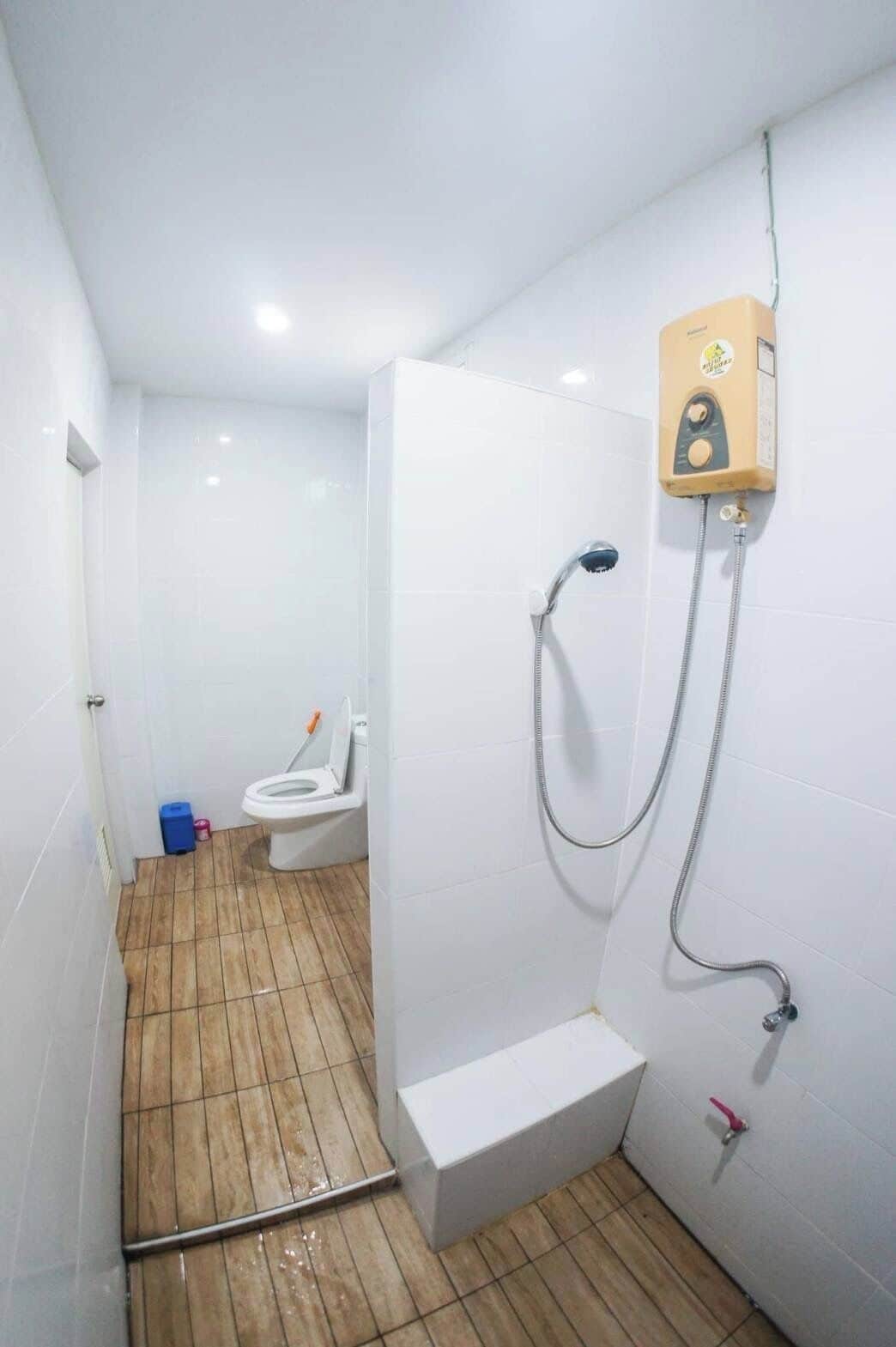 A small bathroom with a toilet, a shower, and a sink.