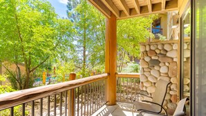 A covered outdoor area with stone walls, wooden railings, and outdoor seating.